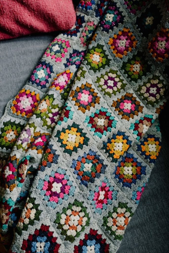 A vibrant handmade crochet blanket featuring geometric patterns in various colors.